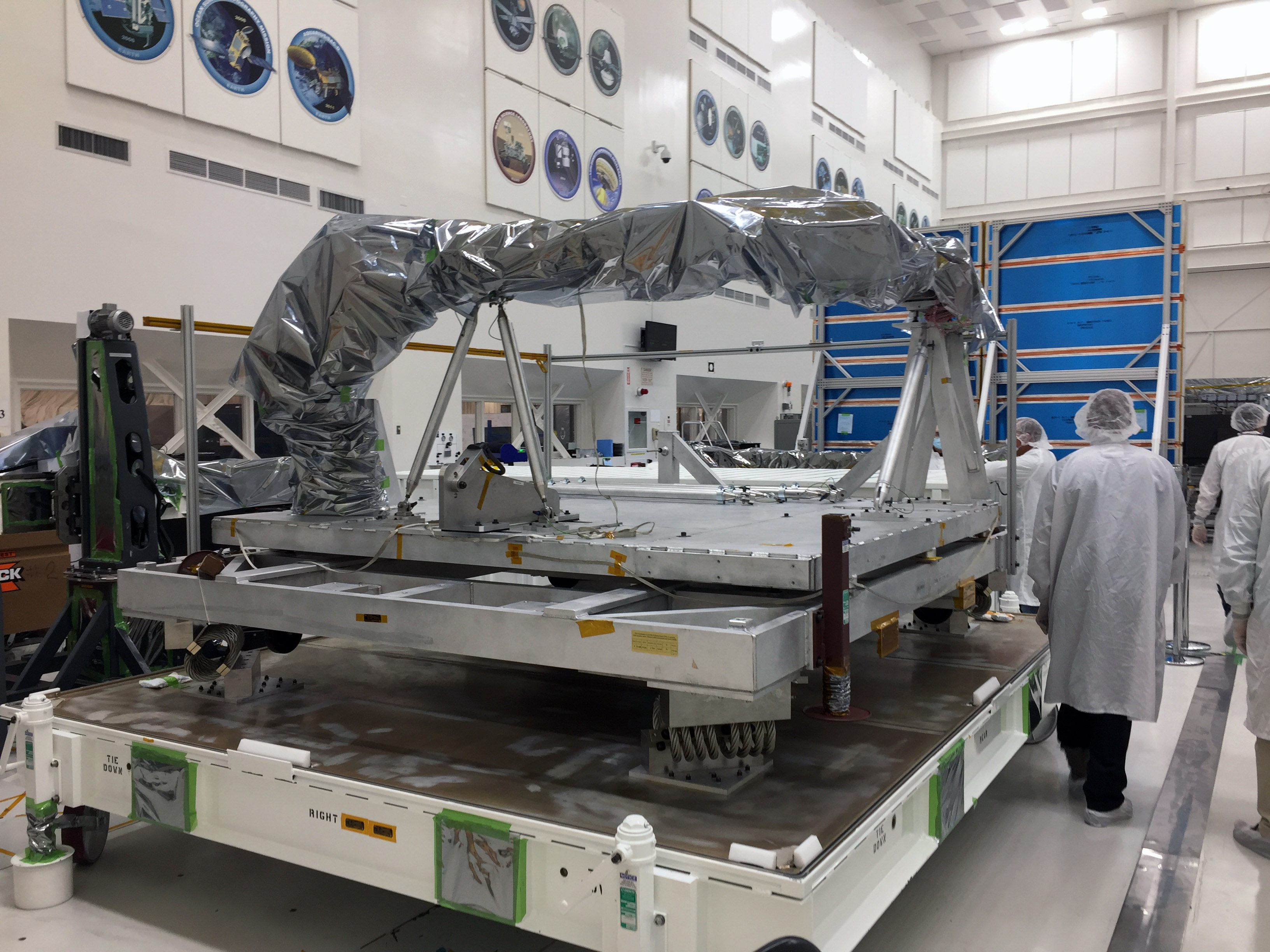 Uncovering NISAR's upper antenna boom assembly at NASA's Jet Propulsion Laboratory.